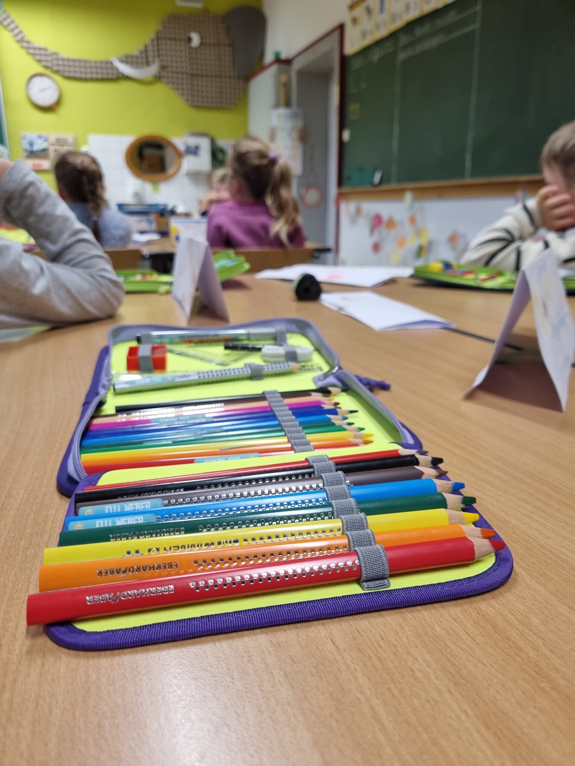 Ein Mäppchen mit vielen Buntstiften liegt auf einem Tisch in einem Klassenzimmer der ersten Klasse der Grundschule Erndtebrück.